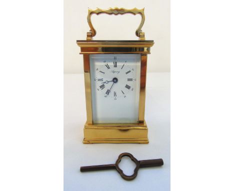 Asprey brass carriage clock of customary form with white enamel dial and Roman numerals, to include key