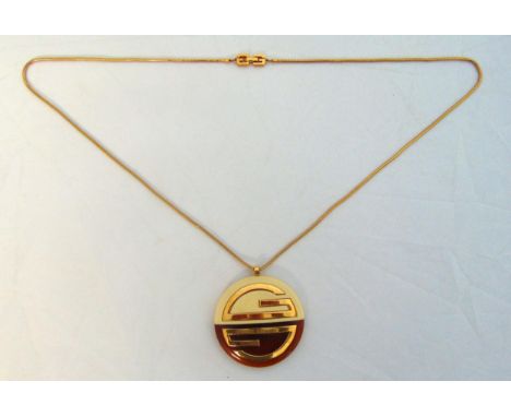 A vintage Givenchy modernist pendant necklace circa 1970 with a circular resin pendant and gold plated chain