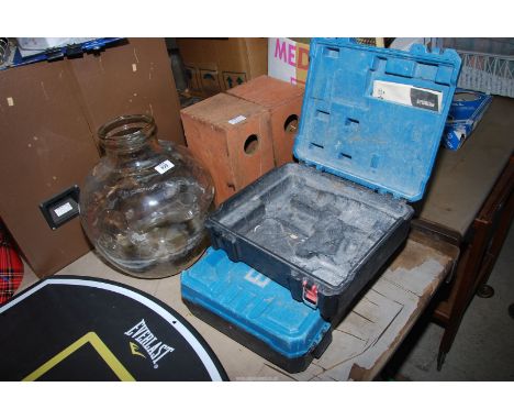 A Carboy. two bird boxes and two empty tool boxes.