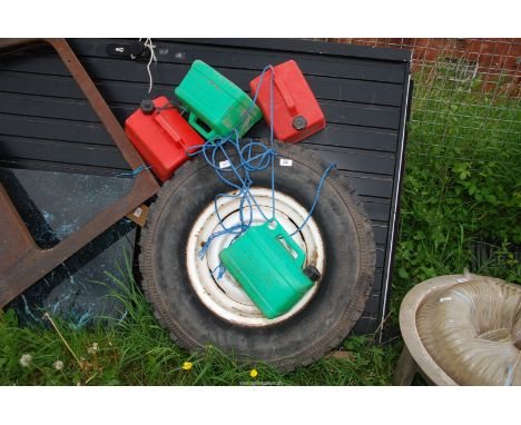 Four plastic fuel cans and a Land Rover wheel and Goodyear tyre 75016.