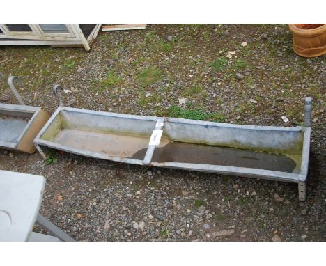 A galvanized gate hanging animal feeder, 53" long x 1' x 5" deep.