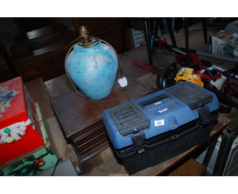 A table lamp, a wooden box and a small, guillotine and a plastic tool box and contents.