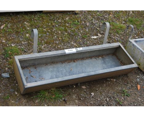 A galvanized gate hanging animal feeder, 3' x 1' x 5" deep.