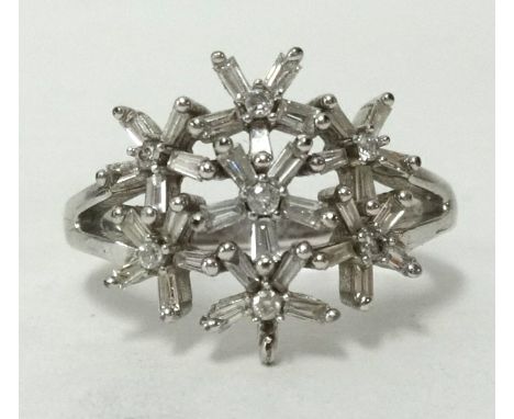 A 9ct white gold baguette cut diamond flower ring (3.7gms), ring size K1/2