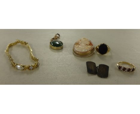 A mixed lot including a 9ct gold dress ring, a 9ct gold onyx set ring, a hardstone pendant, a yellow metal cameo brooch, a si