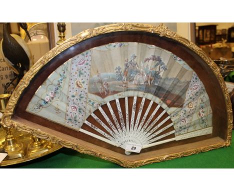 A 19th Century French hand painted fan, the centre panel decorated with figures in a garden setting on pierced ivory sticks