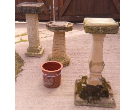 A composite stone bird bath, a composite stone sundial, a composite stone pedestal and a terracotta planter