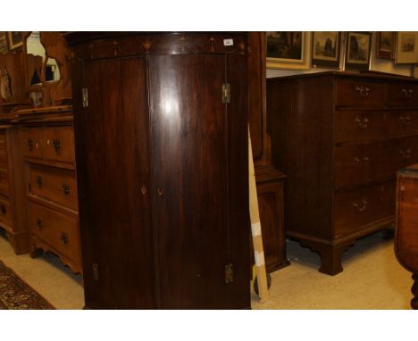 A 19th Century mahogany bow fronted two door wall hanging corner cupboard with satinwood banding to the pediment, above a sat