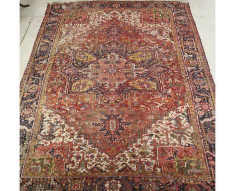 A Hiraz carpet ,the central panel set with stylised motifs on a red and pink ground within a stepped blue, red and yellow sty