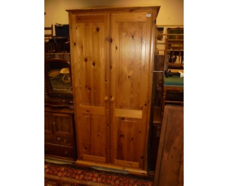 A 20th Century pitch pine two door wardrobe, raised on ogee bracket feet