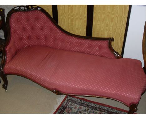 A Victorian show frame chaise longue with pierced and carved decoration, upholstered button back and shaped seat raised on ca