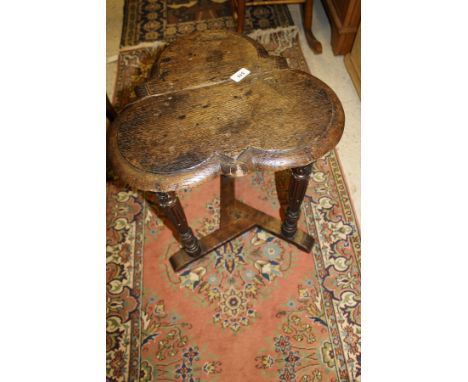 A 19th Century oak occasional table, the trefoil shaped top above three carved and fluted supports united by a tripod base   