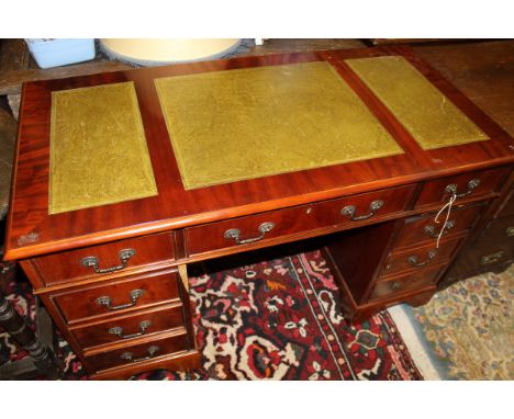 A modern pedestal desk, the plain top with three inset panels above two banks of four drawers and a central drawer, raised on
