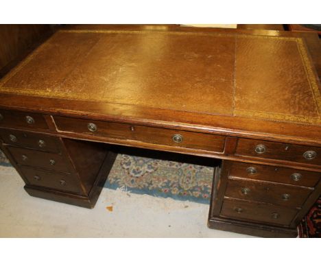 A walnut double pedestal desk, the tooled and gilded leather insert writing surface within a moulded edge above three frieze 