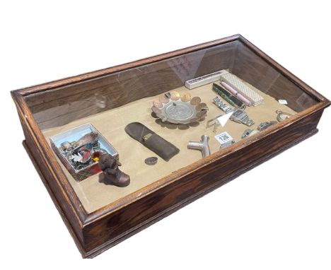 Table top display cabinet containing brooches, lighters, pens, coin ashtray, silver walking stick handle, etc.