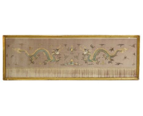 A Chinese silk panel, 20th century, worked with gilt thread with two dragons chasing a flamng pearl above a tasseled frieze, 