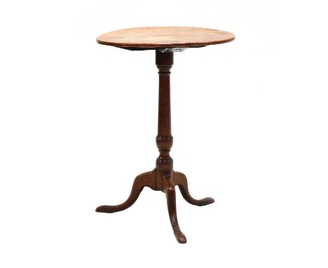 A George III oak and elm tripod occasional table, the circular top raised on a gun-barrel column and outswept tripod supports