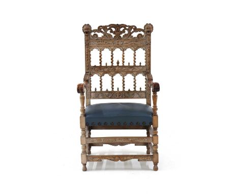 A 19th century limed oak throne chair, the architectural carved back above blue leather stuffover seat, on stretchered suppor