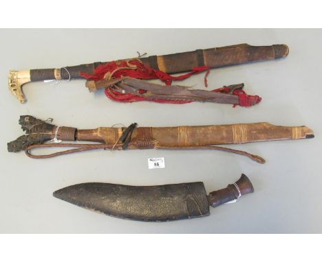 Nepalese kukri with badly damaged wooden handle and leather scabbard, together with a Malay Parang type tribal blade with car