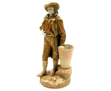 A Hadley's Royal Worcester blush porcelain figure, c1915, of a continental gentleman aside a basket, incised signature verso,