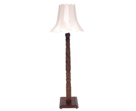 An early 20thC mahogany standard lamp, with spiral fluted and leaf carved column, raised on a stepped square base, with a mus