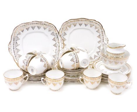 A Royal Worcester porcelain tea service, gilt decorated with scrolling flowers, within a repeating holly border, printed mark