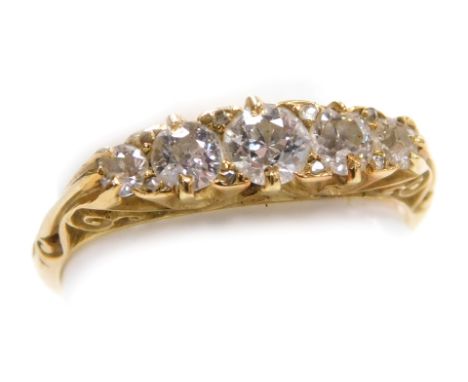 An Edwardian 18ct gold and diamond five stone ring, set with five diamonds graduated to the centre, in a scrolling claw mount