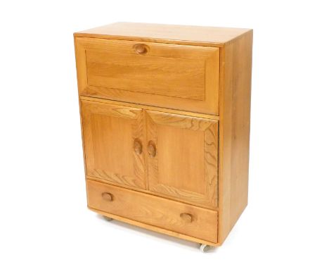 An Ercol light elm drink's cabinet, with a drop down front over a pair of cupboard doors, above a frieze drawer, on castors, 