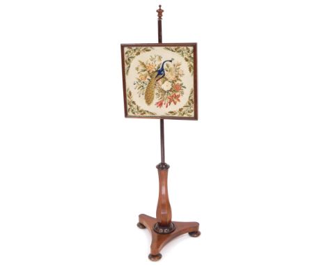 A Victorian mahogany pole screen, the rectangular screen with a peacock and floral tapestry, raised on an octagonal baluster 