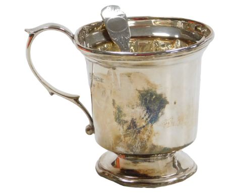 A George III silver caddy spoon, with right cut engraving, and an Elizabeth II silver Christening mug, Birmingham 1979, 2.51o