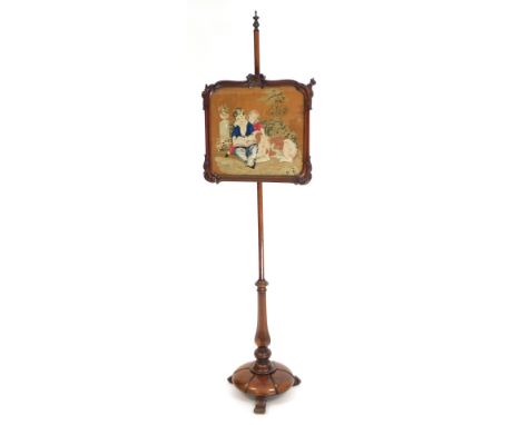 A late Regency rosewood pole screen, the panel with tapestry depicting two children reading with a dog in a garden, the pole 