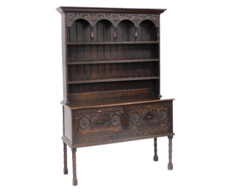 A Victorian oak dresser, the outswept pediment over a three shelf plate rack, with carved frieze and columns to the upper she