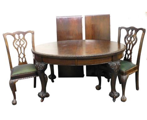 A Victorian mahogany wind out dining table, with two additional leaves, raised on leaf carved cabriole legs, and ball and cla