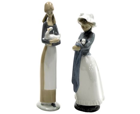 A Nao porcelain figure of a girl with a duck, 27cm high, and a further figure of a girl holding a blanket and a puppy, 26cm h