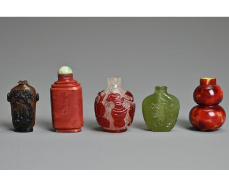A GROUP OF FIVE CHINESE GLASS SNUFF BOTTLES. To include a red overlay clear glass bottle with treasured items; A green glass 