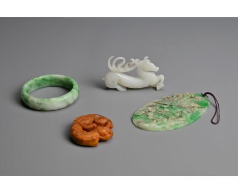 A GROUP OF CHINESE CARVED JADE ITEMS. To include an oval form pedant decorated in relief featuring a phoenix; A bangle; a whi