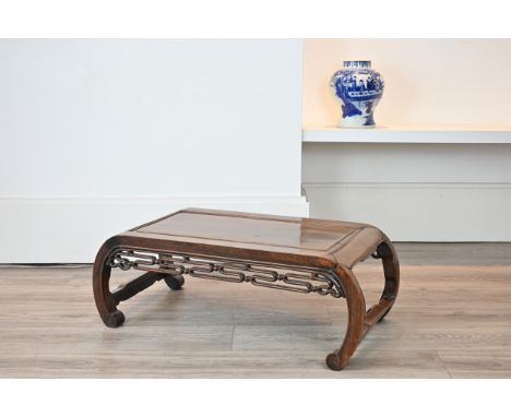 AN EARLY 20TH CENTURY CHINESE CARVED HARDWOOD LOW TABLE. Scroll ended, with moulded top and pierced ball and strapwork frieze