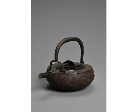 A 20TH CENTURY JAPANESE CAST IRON CHOSHI (SAKE EWER), of squat form on tripod feet with black lacquered wood cover and cast d