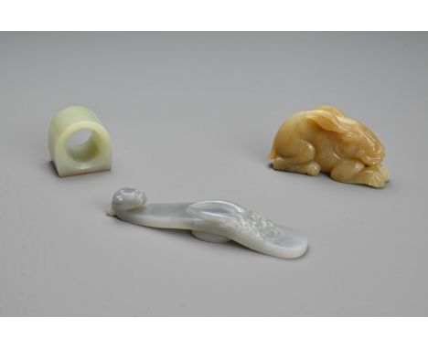 THREE CHINESE CARVED JADE ITEMS. To include a pendant in the form of a hare; A thumb ring; Together with a grey dragon head b