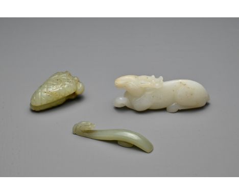 THREE CHINESE CARVED JADE ITEMS. To include a white jade model of a recumbent deer; A small celadon dragon head belt hook; To