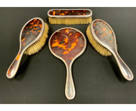 A four piece silver and tortoise shell dressing set including; brushes, combs and a mirror, London 1922 (4)