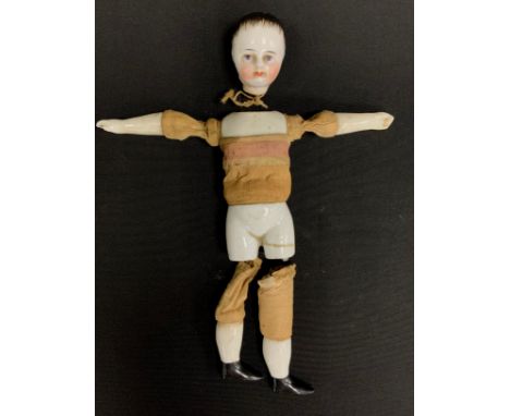 A miniature continental porcelain boy doll, ceramic shoulder, limbs and lower torso, fabric and wooden midriff , in need of r