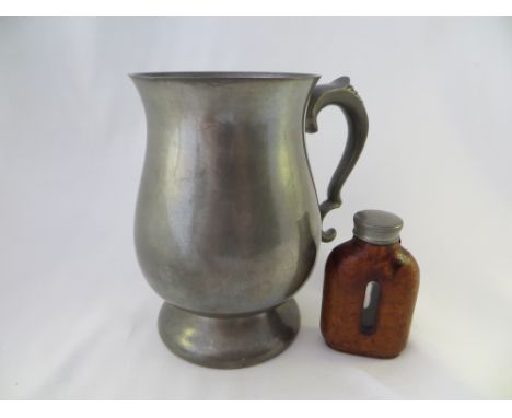 A pewter tankard and a small bottle with a leather outer casing.