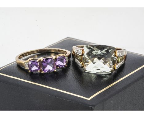 A 9ct gold green quartz dress ring, multi faceted table, ring size N, together with a three stone amethyst and diamond ring, 