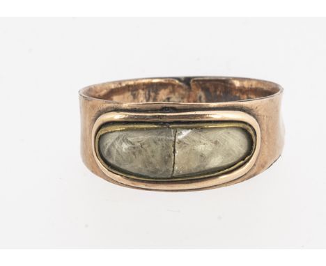 An early 19th century Georgian mourning ring, inscribed and dated, the oval white panel of plaited hair under a glass cabocho