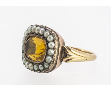 A 19th century yellow paste and seed pearl dress ring, rectangular cut stone surrounded with half cut pearls, on a shaped sha