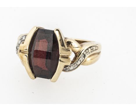 A 9ct gold garnet and diamond dress ring,  the oval faceted table cut garnet, on a twisted shank, with a hallmarked shank, ri