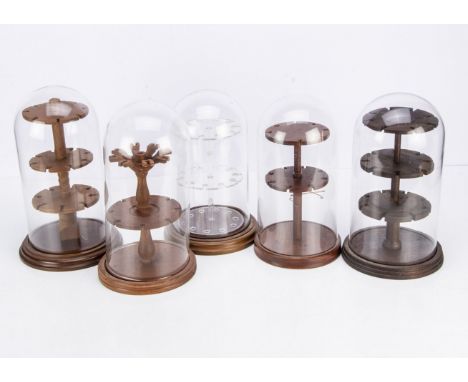 Five modern presentation stands under domes, three glass domes, tallest 31cm, and two with plastic domes, used to present tea