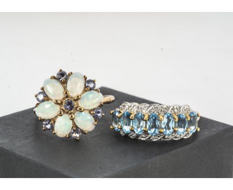 A 9ct gold blue topaz and diamond dress ring, the mixed oval claw set stones, with eight cut diamonds on a yellow gold shank,