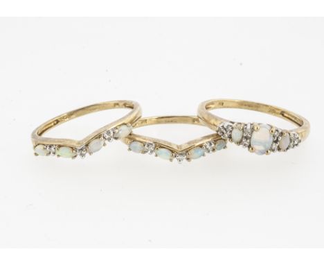 A set of three opal and diamond dress rings, each claw set white opal, set with eight cut diamonds, ring size S, 5.3g 